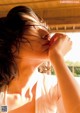 A woman with her hand on her chin looking out a window.