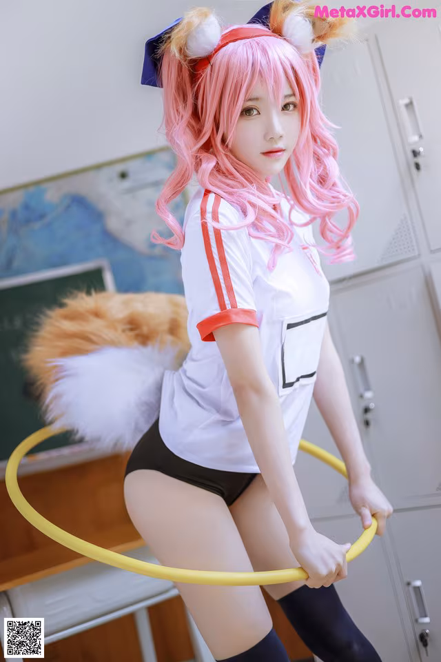 A woman with pink hair holding a hula hoop.