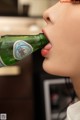 A woman is drinking from a bottle of beer.