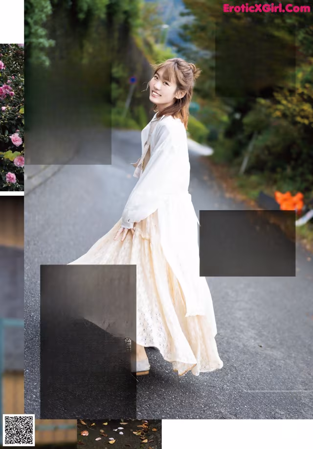 A woman in a white dress is walking down the street.