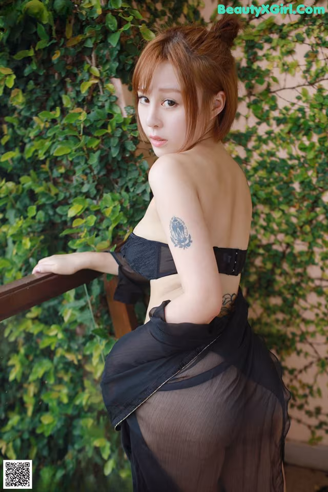 A woman in a black dress posing for a picture.