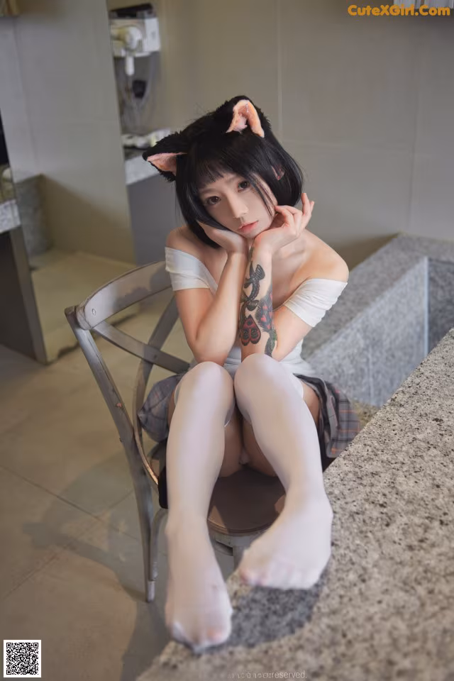 A woman sitting on a chair in a bathroom.