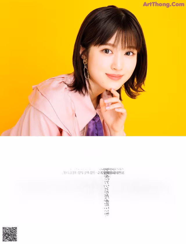A woman in a pink shirt and purple tie posing for a magazine.