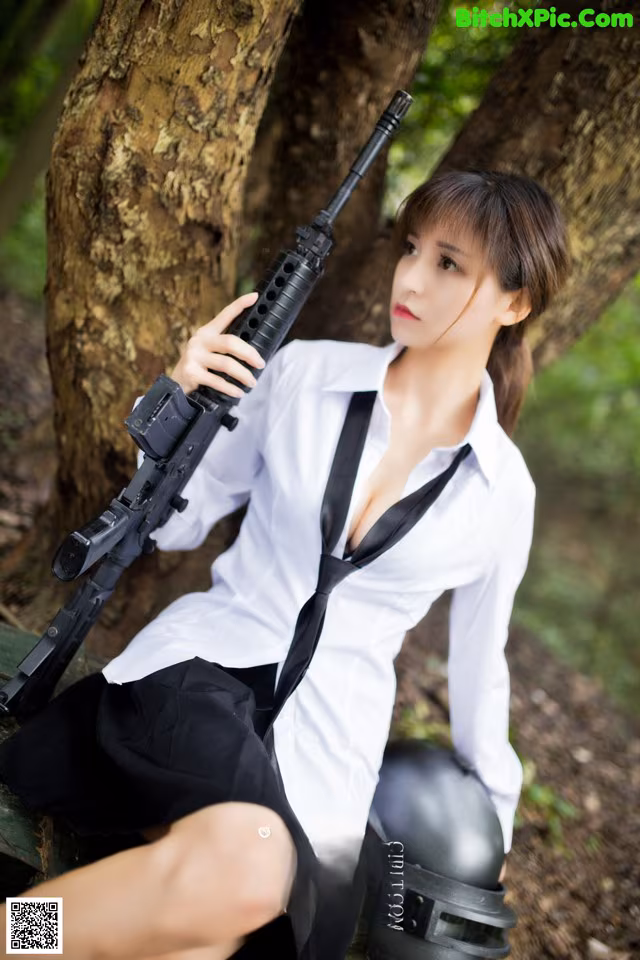 A woman in a white shirt and black skirt holding a rifle.