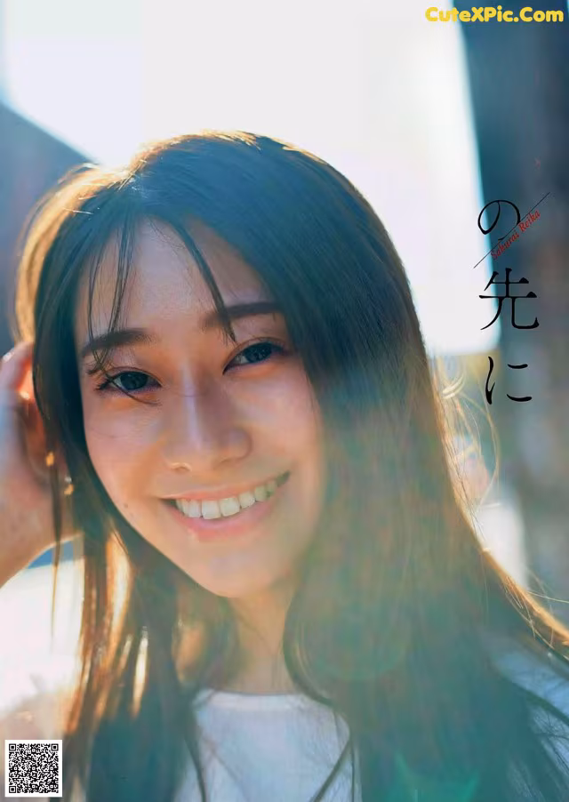 A woman with long black hair smiles at the camera.