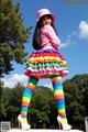 A woman in a pink hat and colorful skirt posing for a picture.